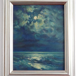 May include: Oil painting of a moonlit seascape. The artwork depicts a full moon shining through clouds over a dark ocean. The waves are illuminated by the moonlight, and the painting is framed in a silver-colored frame.