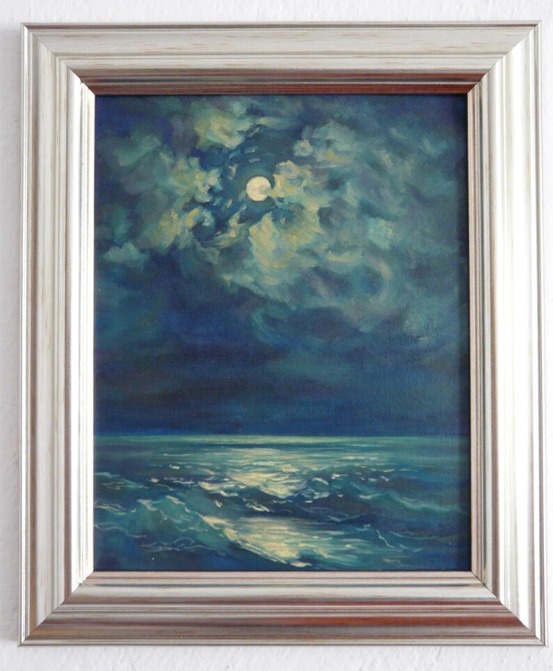 May include: Oil painting of a moonlit seascape. The artwork depicts a full moon shining through clouds over a dark ocean. The waves are illuminated by the moonlight, and the painting is framed in a silver-colored frame.