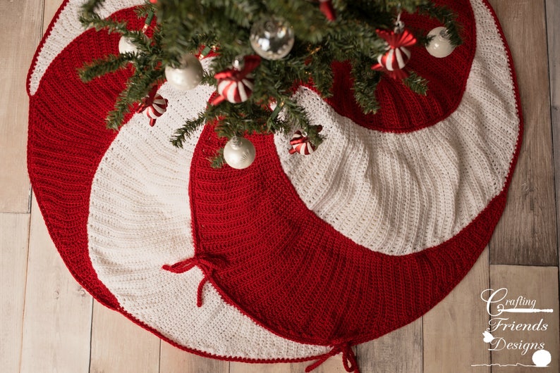 May include: A red and white crocheted Christmas tree skirt with a candy cane swirl design. The skirt has two ties on each side.