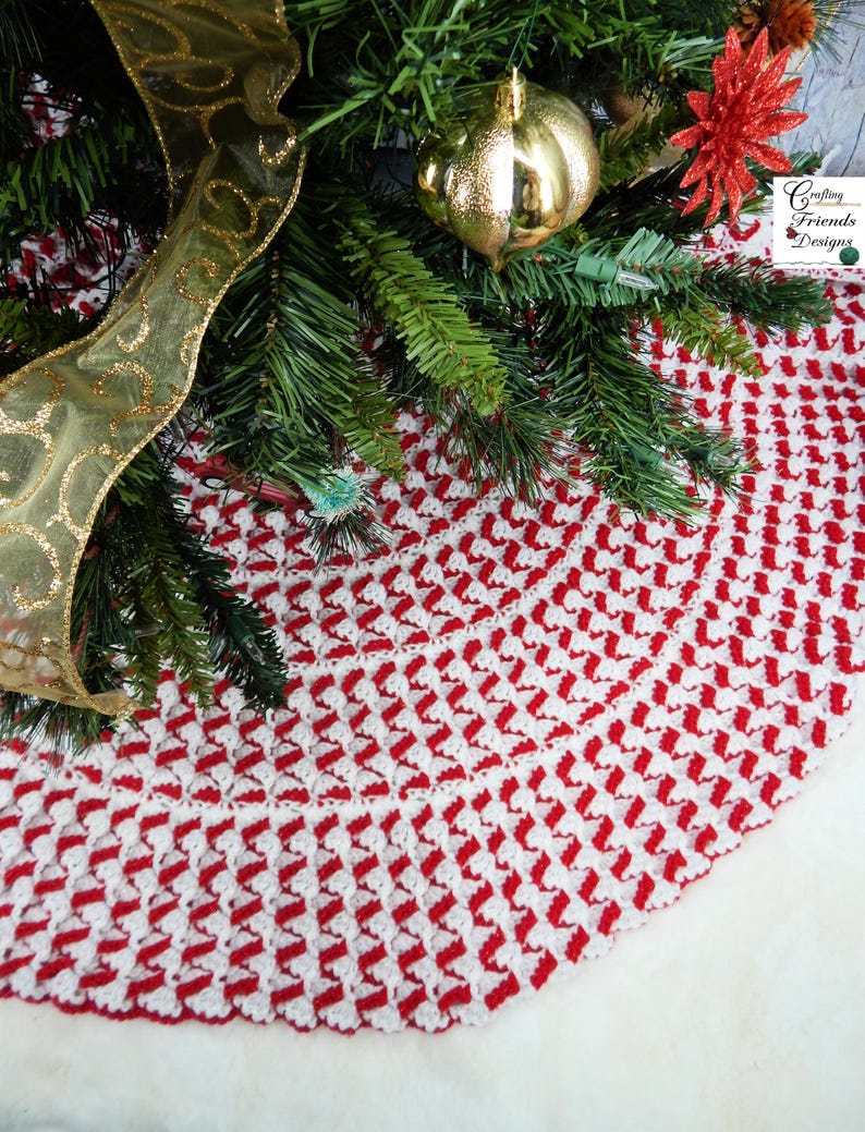 May include: Red and white crocheted Christmas tree skirt with a scalloped edge. The skirt is made with a repeating pattern of diagonal stripes.