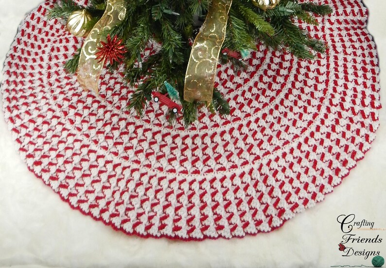 May include: A red and white crocheted Christmas tree skirt with a scalloped edge. The skirt is made with a textured stitch pattern.