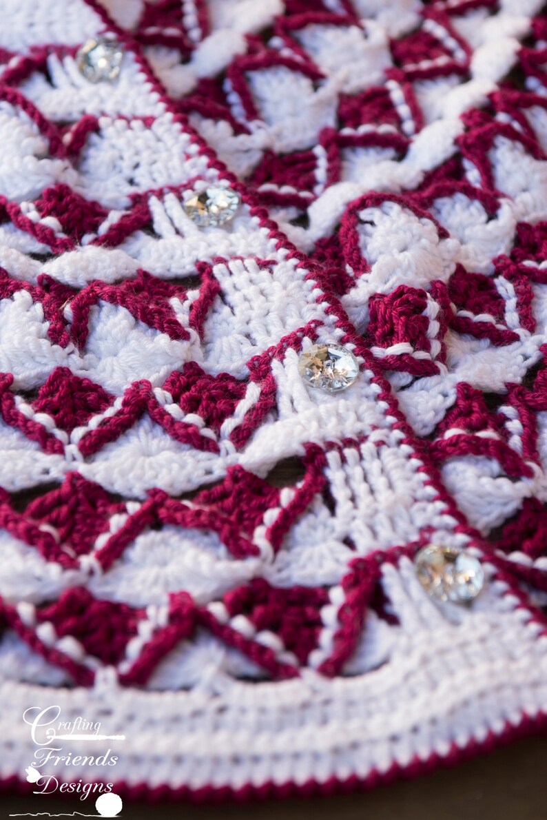 May include: Close-up of a crocheted fabric with a white and burgundy pattern. The fabric is decorated with clear rhinestones.