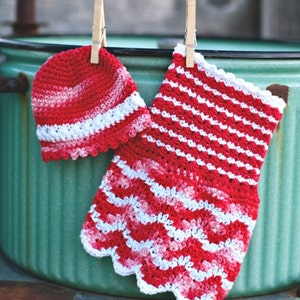 May include: A red and white crocheted hat and a matching crocheted dress hanging on a clothesline.