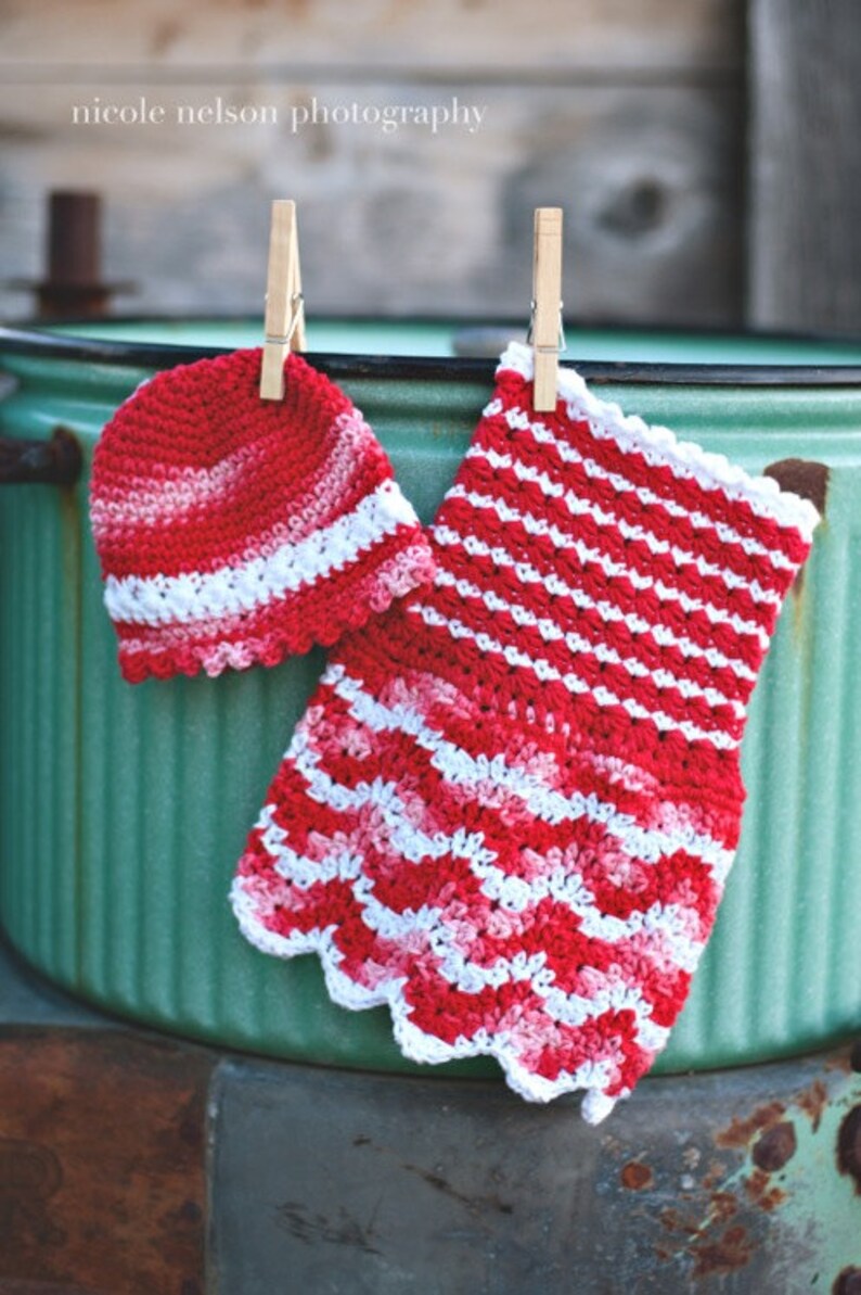 May include: A red and white crocheted hat and a matching crocheted dress hanging on a clothesline.
