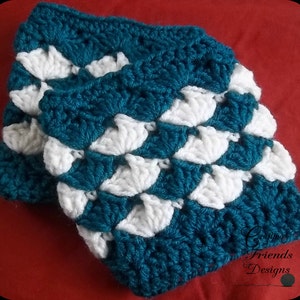May include: Two crocheted leg warmers in teal and white. The leg warmers are made with a shell stitch pattern. The leg warmers are folded over each other.