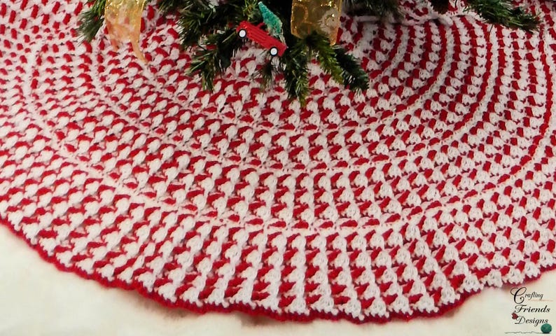 May include: A red and white crocheted Christmas tree skirt with a scalloped edge.