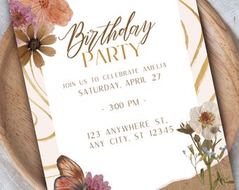 May include: A rectangular birthday party invitation card featuring floral illustrations, a butterfly, and gold wavy lines. The text reads: Birthday PARTY, JOIN US TO CELEBRATE AMELIA, SATURDAY, APRIL 27, 3:00 PM, 123 ANYWHERE ST., ANY CITY, ST 12345.