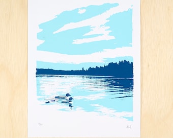 May include: A blue and white print of a lake scene with two loons swimming in the water. The sky is a light blue with white clouds. The trees on the shore are dark blue.