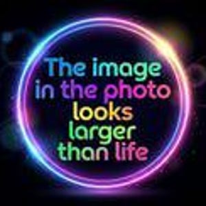 May include: A circular neon light frame in shades of blue, purple, and pink against a black background. Inside the circle, the text reads: The image in the photo looks larger than life. The text is displayed in multiple colors including blue, pink, and green.