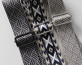 May include: Three woven bag straps with metal hardware. One strap features a geometric pattern in navy, white, and beige. The other two straps have a herringbone pattern in shades of gray. The straps are designed for bags.