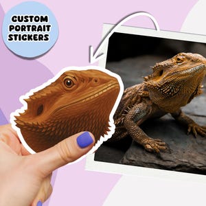 Peut inclure: Un autocollant avec une illustration détaillée d'un dragon barbu, tenu par une main avec du vernis à ongles bleu. L'autocollant est à côté d'une photo encadrée d'un dragon barbu. Le texte sur l'autocollant dit "CUSTOM PORTRAIT STICKERS".