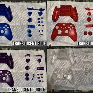 May include: Four sets of disassembled game controller shells and buttons in translucent blue, red, purple, and clear. Each set includes a front faceplate, a back housing, and various small buttons and triggers arranged on a patterned surface.