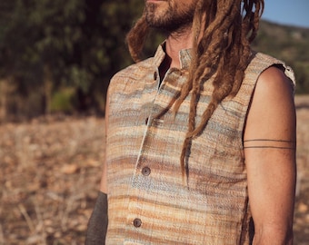 May include: A sleeveless, button-down vest in a woven fabric with horizontal stripes of brown, tan, and blue. The vest is paired with light-colored pants. The image shows a close-up of the vest and pants.