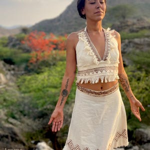 a woman wearing white top and cotton wrap skirt in a natural setting