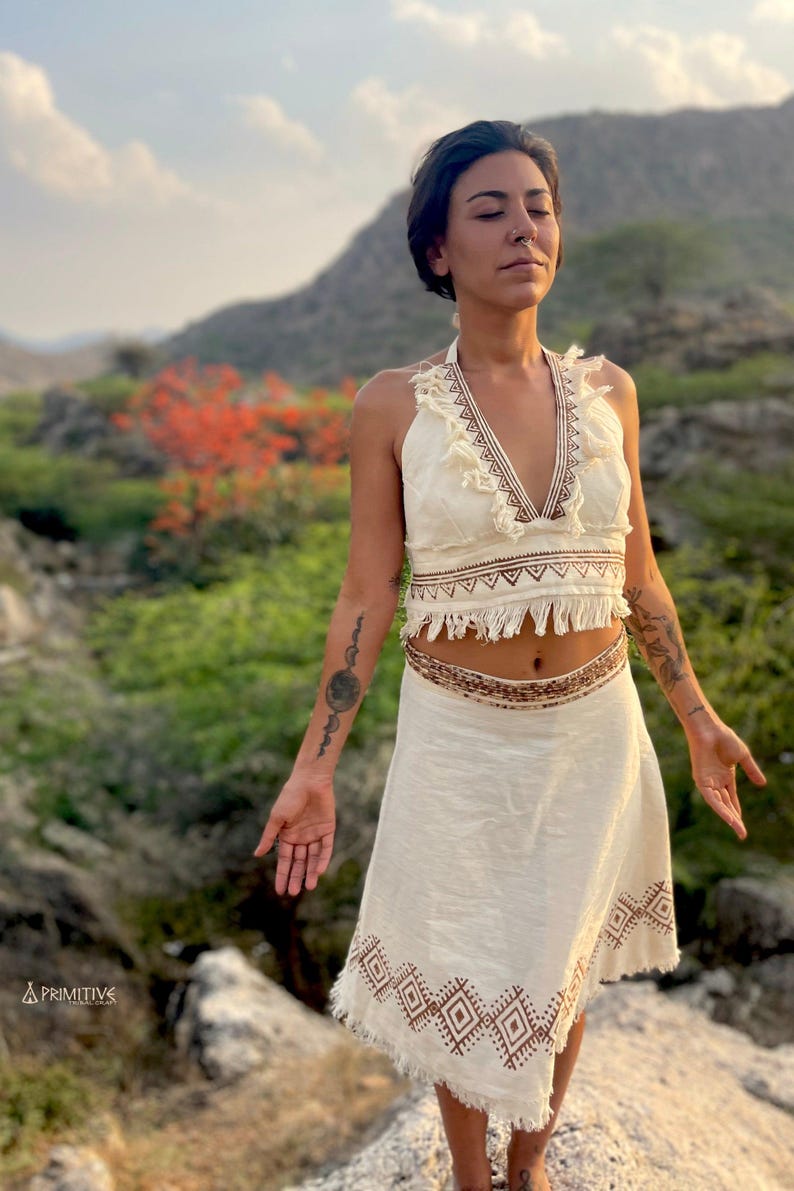 a woman wearing white top and cotton wrap skirt in a natural setting
