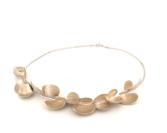 Collana insolita, modernista e delicata, in argento opaco spazzolato, pezzo scultoreo