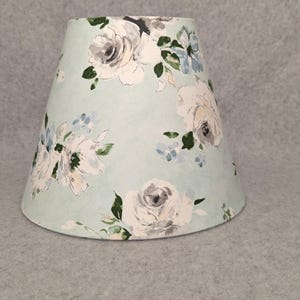 Lite green with white and pink flowers lamp shade.  Green background.  Grey. Plants.  Flowers. Shades are 9.5&quot; x 5&quot; x 7&quot; tall