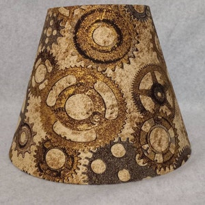Gears, cogs, sprockets lamp shade.  Gold, rust, shimmer. Shade is 9.5" wife at the bottom, 5" wide at the top and 7" tall