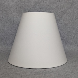 May include: A white lampshade with a conical shape. The lampshade is made of a smooth, opaque material and has a slightly flared base. The lampshade is designed to diffuse light and is suitable for various lamp bases.