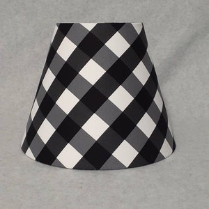 May include: A black and white gingham lampshade with a white background and black and gray squares.