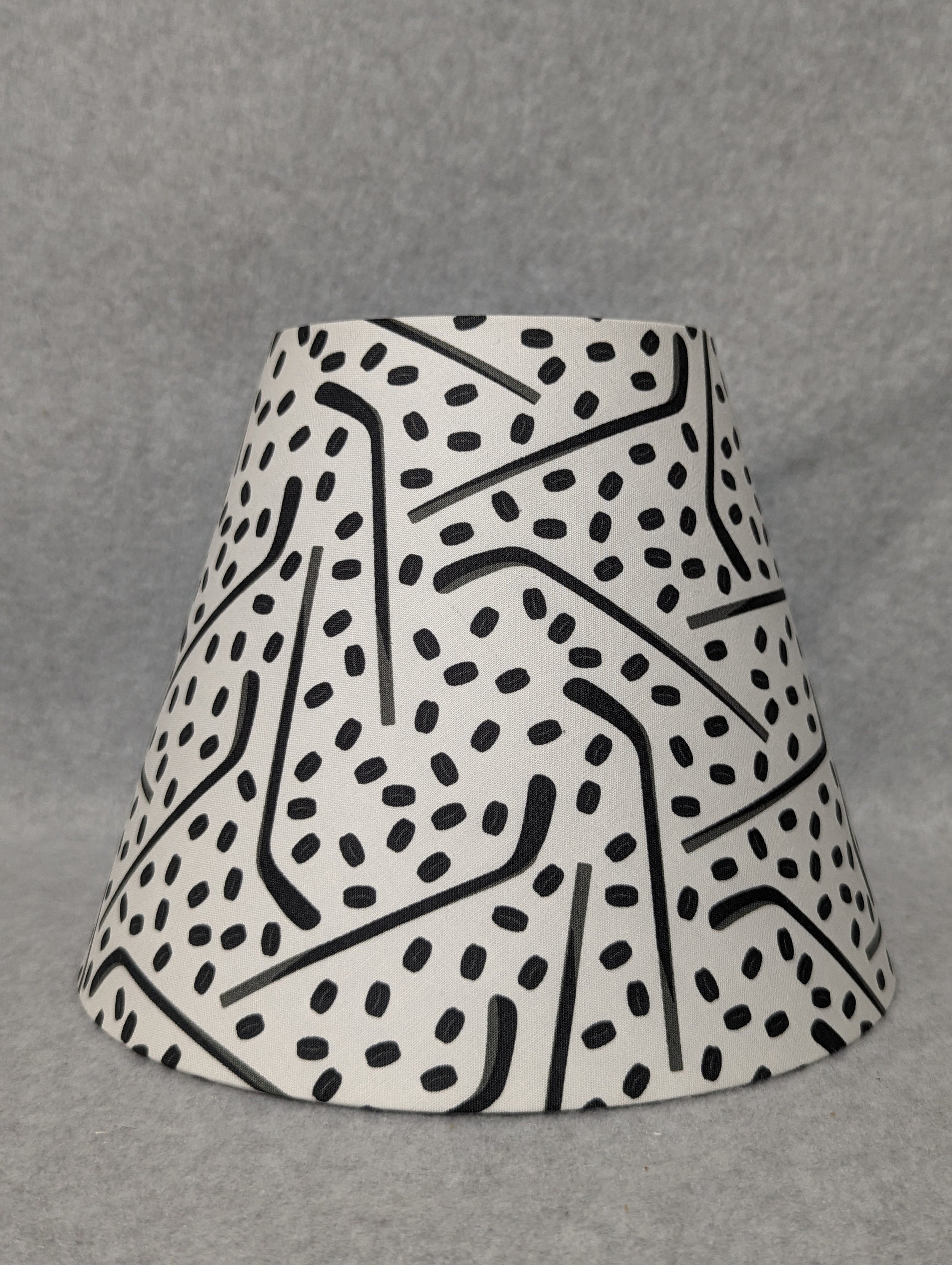 Hockey lamp shade.  Pucks and sticks.  Black and off-white.  Shades are 9.5" x 5" x 7" tall