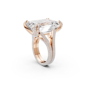 A regal name fitting for this luxurious design, featuring a large emerald-cut center stone, The Crown Jewel