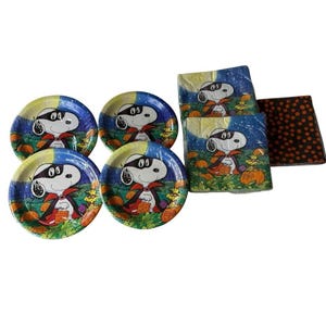 May include: A set of Halloween-themed party supplies featuring Snoopy dressed as a vampire. The set includes five round paper plates, napkins, and a small, square, polka-dotted item. The plates and napkins have a colorful illustration of Snoopy with pumpkins.