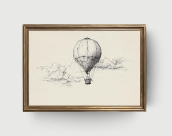May include: Pen and ink drawing of a hot air balloon floating in the sky, framed in a gold-colored frame. The balloon is detailed with lines, and the clouds are sketched in the background. The artwork is on a cream-colored background.