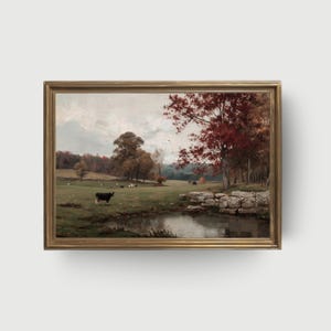 Puede incluir: Pintura de paisaje enmarcada que representa una escena pastoral. Una vaca negra está en un campo verde con otras vacas pastando. Un estanque refleja el cielo y los árboles con hojas rojas y marrones. La pintura está en un marco dorado.