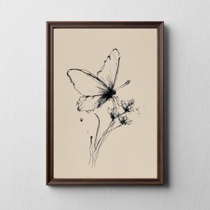 May include: A framed art print featuring a delicate black ink illustration of a butterfly perched on a flower. The artwork is set against a beige background and enclosed in a dark brown wooden frame, creating a classic aesthetic.