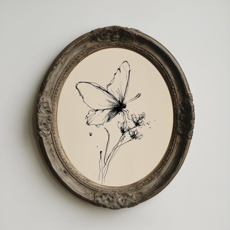 May include: Oval framed artwork featuring a black ink drawing of a butterfly perched on a flower. The butterfly and flower are centered on a cream-colored background. The frame is a distressed, ornate, dark brown color.
