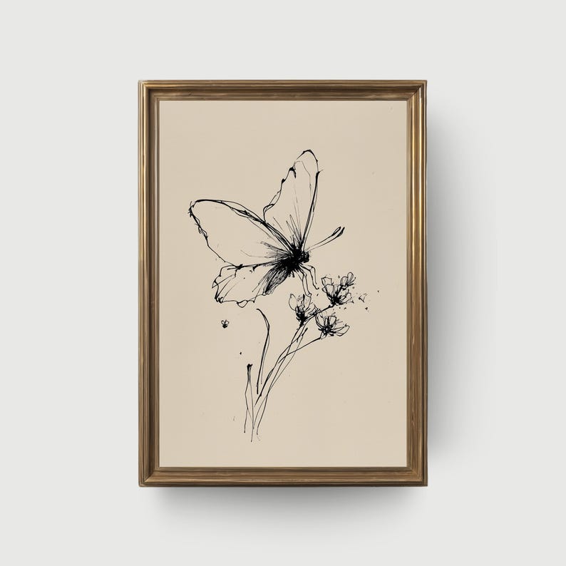 May include: A framed black and white ink drawing of a butterfly perched on delicate flowers. The artwork features fine lines and shading, set against a neutral background. The frame is a warm gold color, adding a touch of elegance to the botanical illustration.