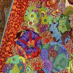 The image is a vibrant and colorful collage of various patterns and designs, including flowers, leaves, and abstract shapes in a variety of bright colors such as orange, green, blue, and purple.