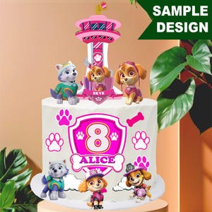 Op de afbeelding: Een op maat gemaakte verjaardagstaart met Paw Patrol-personages en een roze en wit ontwerp. De taart is versierd met het nummer 8, de naam "ALICE", pootafdrukken en een bot. De taart is bekroond met Skye en andere Paw Patrol-figuren.