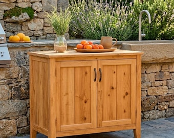 May include: A rectangular wooden outdoor cabinet with two doors and dark metal handles. The cabinet features a natural light brown wood grain finish, a flat top surface, and four sturdy legs, providing storage space for outdoor areas.