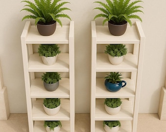 May include: Two white wooden plant stands, each with five shelves, display various potted plants. The top shelf of each stand holds a large fern in a brown pot. Smaller plants in white, gray, and blue pots are on the lower shelves.