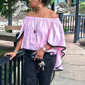 This loose fitting, pullover top, has an off the shoulder overlay cape in front and back!