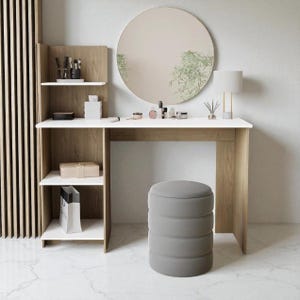 Pode incluir: Uma penteadeira moderna com tampo branco e detalhes em madeira clara. Possui um espelho redondo, um banco cinza e prateleiras para armazenamento. O conjunto inclui uma lâmpada e vários cosméticos, criando um espaço funcional e elegante.