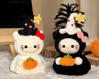 May include: Two crochet figures, one white and one black, each resembling a cat. The white figure wears a witch hat with orange accents and holds an orange pumpkin. The black figure wears a ghost hat and holds a pumpkin. Halloween-themed decor.