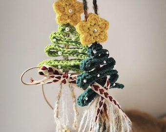 May include: Three handmade crochet Christmas tree ornaments. The trees are green and dark green, with yellow star toppers and pearl accents. Each ornament has a decorative ribbon and yarn embellishment.