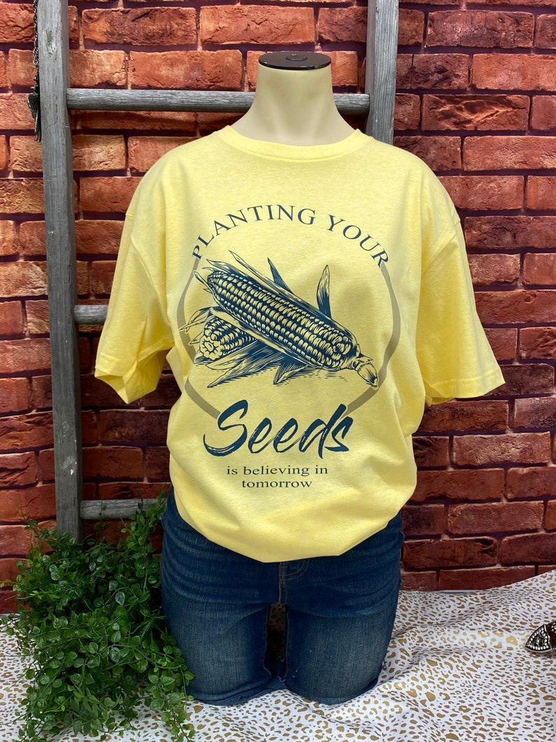May include: Yellow t-shirt with a graphic of corn and the text "Planting Your Seeds is believing in tomorrow."