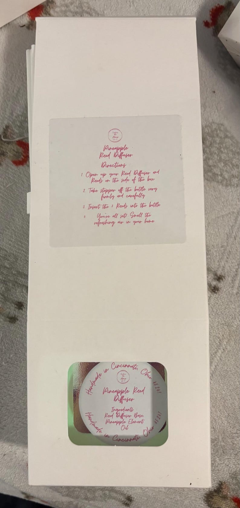 May include: A rustic wooden sign with the text "Welcome" in a handwritten style. The sign is painted white with a distressed finish, and features a decorative floral element in the corner. The background is a blurred image of a wooden surface.