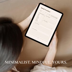May include: A digital tablet displaying a "Mood Tracker" template. The template includes sections for daily mood, challenges, highlights, and affirmations. The text "MINIMALIST. MINDFUL. YOURS." is at the bottom of the image.