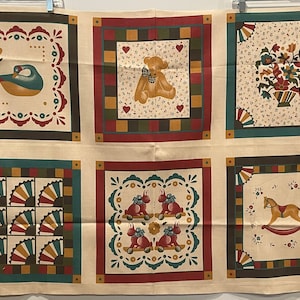 May include: A beige fabric with six colorful squares featuring different designs. The squares feature a bird, a teddy bear, a flower arrangement, a fan pattern, a bunny on wheels, and a rocking horse.