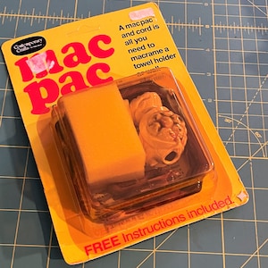 May include: A yellow mac pac kit for macrame towel holders. The kit includes a yellow sponge, macrame cord, and other components in a clear plastic package. The packaging has red text that reads "mac pac" and "FREE Instructions included."