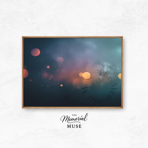 May include: A framed art print featuring a dreamy, abstract design. The artwork showcases a dark blue and teal background with soft orange and yellow bokeh effects. The text "The Memorial Muse" is visible.