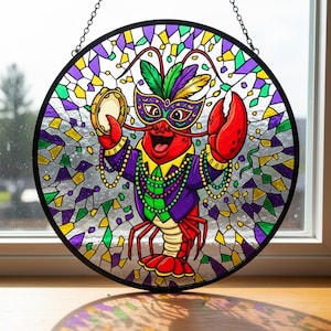 Op de afbeelding: Een ronde glas-in-lood raam met een cartoon kreeft in een Mardi Gras masker en kostuum. De kreeft is rood met paarse en groene accenten, met een tamboerijn. De achtergrond is een mozaïek van gekleurde glasstukken.