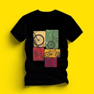 May include: Black t-shirt with a graphic design of BMX bike illustrations in yellow, green, and red squares. The design includes bike wheels and full bike silhouettes, creating a vintage, distressed look. The shirt is made of a soft material.