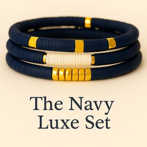 Puede incluir: Tres pulseras azul marino con detalles cuadrados dorados. Una pulsera presenta una sección blanca. El texto "The Navy Luxe Set" se muestra debajo.