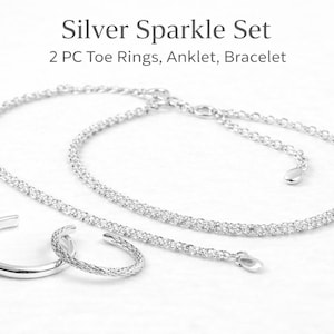 May include: A silver sparkle set including two toe rings, an anklet, and a bracelet. The jewelry is silver and has a delicate, sparkling design. The text "Silver Sparkle Set" is at the top of the image.